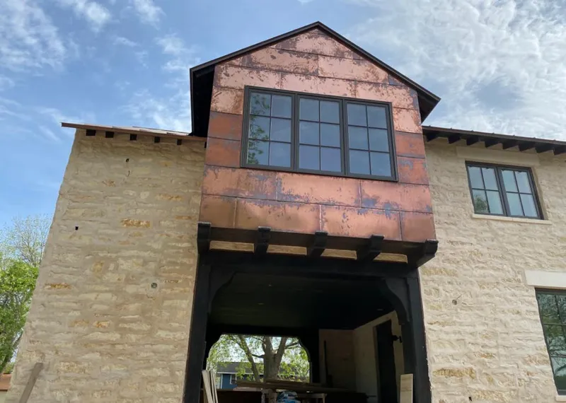 Copper metal panel facade on a stone building for Skylight Installation in Boone